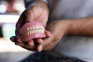 tandprotes i handen på äldre kvinnor på landsbygden i Thailand. foto