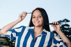 närbild av leende tonåring kvinna ansikte tillämpa rouge med makeup borste. foto