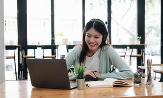 e-learning online utbildning koncept. asiatisk kvinna uppmärksam student student videokonferens e-learning med lärare på bärbar dator hemma foto