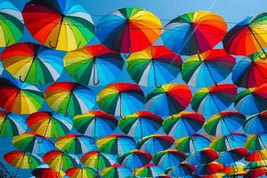utomhus dekoration med många färgglada paraplyer mot blå himmel och sol foto