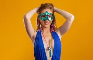 vacker kvinna klädd för karnevalskväll. leende kvinna redo att njuta av karnevalen med en färgglad mask. foto