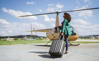 framgångsrik smart snygg ung latinsk kvinna nära helikopter. lyxigt livsstilskoncept foto