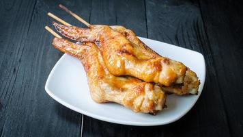 grillade kycklingvingar i maträtt på selektiv foc av träbakgrund