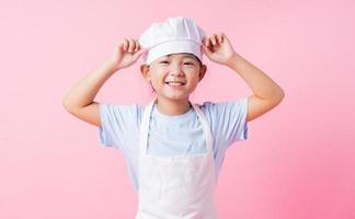 bild av asiatiskt barn som övar för att vara kock foto