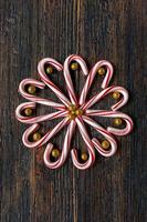 godisrör i blomdesign med glitterguldkulor på rustikt träbord platt lay foto