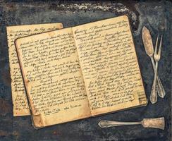 antika bestick och vintage handskrivna receptbok foto