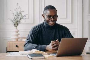 positiv afroamerikansk manlig privat konsult som har session online lyssnar uppmärksamt på klienten foto