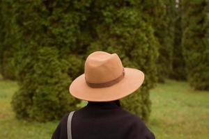 kvinna i hatt går ensam i den vackra höstparken foto