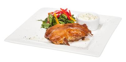 stekt kyckling med grönsaker på en vit platta foto
