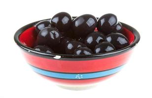 oliver svart vattnas med olivolja i en skål isolerad på en vit bakgrund foto