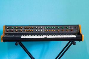 gammal synthesizer med färgstarka strömbrytare på blå bakgrund foto