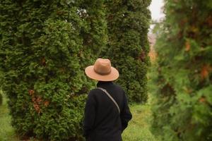 kvinna i hatt går ensam i den vackra höstparken foto