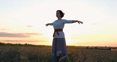 kvinna utövar qigong i sommarfält med vacker solnedgång på bakgrunden foto