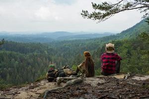 ett par resenärer som står på klippan och tittar på vackra berg och skogar foto