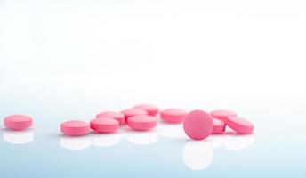 runda rosa tabletter piller på vit bakgrund. vitaminer och mineraler plus folsyra vitamin e och zink i läkemedelsflaska på gradientbakgrund. rosa tabletter piller för under och efter graviditet kvinna. foto