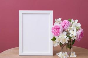 tom vit ram mock up med blommor på rosa bakgrund. mall för din text eller bild foto