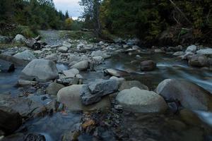 berg flod med stenar, skog och stenar bakgrund foto