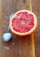 skivad grapefrukt med socker på träplanka