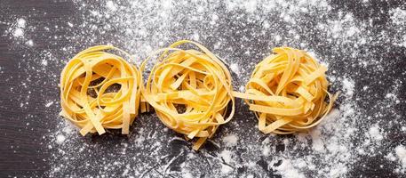 rå pasta-tagliatelle på bordet foto