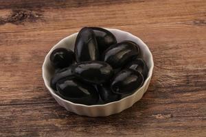 inlagda svarta oliver i skålen foto