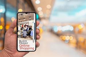 svart fredag shopping app i en mobiltelefon skärm med oskärpa interiör i köpcentret. foto