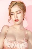 vacker ung asiatisk kvinna med ren fräsch hud i fönsterbelysning på rosa bakgrund. plastikkirurgi, anti-aging, kosmetologi, skönhet och spa, ansiktsvård, solkräm, kvinnoporträtt. foto