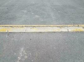 förhöjd asfalt eller trottoarväg med gul trottoarkant eller ramp foto