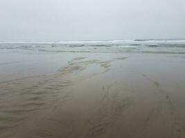 strand med våt sand, hav och vågor foto