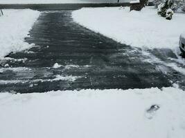 asfalt uppfart med vit snö skottning på vintern foto