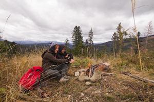 ungt par vandrare med termoskoppar i skogen, resenärer på berg som dricker te eller kaffe foto