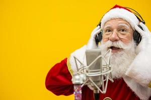 jultomten sjunger eller talar i en studiomikrofon. god Jul. sändare. utropare. befordran. julmusik koncept. foto