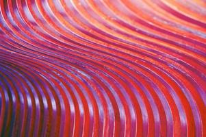 trendigt abstrakt mönster av träribbor, trästruktur målade i vinrött. bländning av solen på en krökt yta, en vacker färggradient. foto