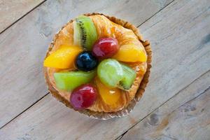 närbild danska bakverk med frukt på träbord foto
