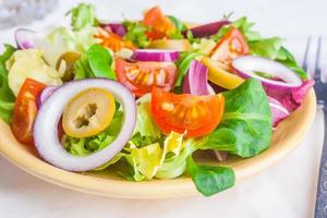 vegetarisk sallad med sallad, tomater, oliver och lök foto