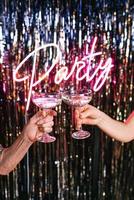 två händer av mogna kvinnor som dricker mousserande vin på festen. helgdagar, livshändelse, firande koncept foto
