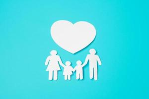 glad familjedag. pappersform urklipp med pappa, mamma, barn och hjärta. internationella familjedagen, varmt hem, kärlek, fosterhem, försäkring, välgörenhet och donationskoncept. foto