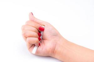 vuxen kvinna hand med röd spik krossad cigarett på vit bakgrund. sluta röka koncept. 31 maj världsdagen för tobaksfri. kvinna hand förstör cigarett. rökavvänjning hos gravida kvinnor. foto