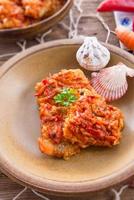 fisk i grekiskt slag med grönsaker och tomatsås foto