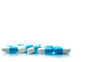 hög med blå och vita kapslar piller isolerad på vit bakgrund med skuggor och kopiera utrymme för text. globalt hälsovårdskoncept. foto