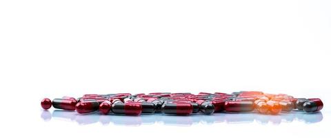 selektiv inriktning av röd-grå kapsel piller på vit bakgrund med utrymme. läkemedelsindustri. apoteksprodukt. läkemedelstillverkning. läkemedel globalt hälsovårdskoncept. foto