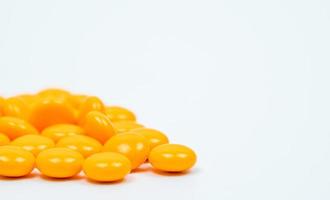 gula sockerdragerade tabletter piller på vit bakgrund med kopia utrymme. medicin för behandling av förstoppning. foto