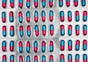 färgglad av blå, rosa kapsel med granulat i sidopiller. piller i blisterförpackning på vit bakgrund med utrymme. farmaceutisk doseringsform och förpackning.medicin mot svamp. foto
