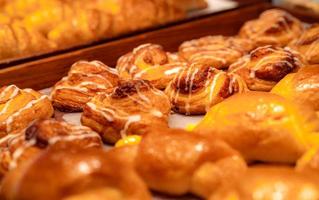 bageri i brun träbricka i bageributik. färsk bakverk produkt. sött bröd display på disk. kolhydrater mat. mellanmål till frukost eller lunch. bageributik. hemgjord bageriverksamhet. foto