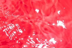 röd abstrakt bakgrund i oskärpa. suddig vätskeyta i livligt rött. foto