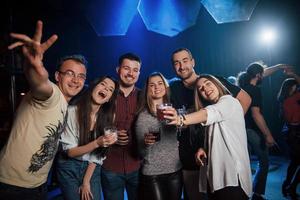 glada vänner. vackra ungdomar har fest tillsammans med alkohol på nattklubben foto
