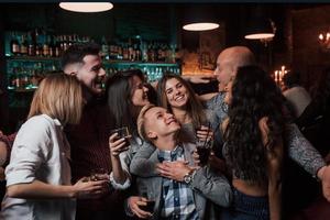 kvinna kramar killen framför henne. vackra ungdomar har fest tillsammans med alkohol på nattklubben foto