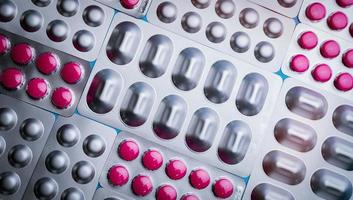 rosa tabletter i blisterförpackning och silveraluminiumfolieförpackning för kapsel och tabletter piller inom läkemedelsindustrin. tillverkning av läkemedelsförpackningar. ovanifrån av runda tabletter piller. apotek. foto