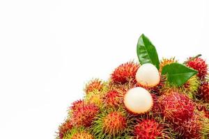närbild av färsk röd mogen rambutan nephelium lappaceum med löv isolerad på vit bakgrund. thai dessert söta frukter. tropisk frukt. foto
