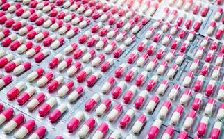 närbild rosa-vita antibiotika kapsel piller i blisterförpackning. antimikrobiell läkemedelsresistens. läkemedelsindustri. global sjukvård. apotek bakgrund. farmaceutisk produkt. amoxicillin kapsel foto