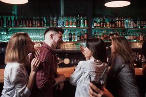 lugnt samtal. vackra ungdomar har fest tillsammans med alkohol på nattklubben foto